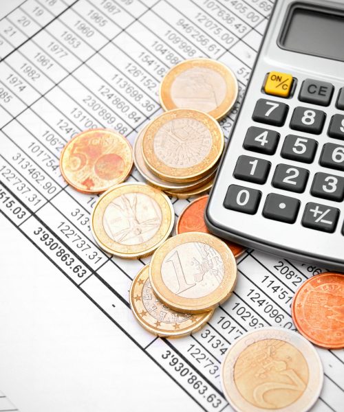 Calculator and coins on the documents